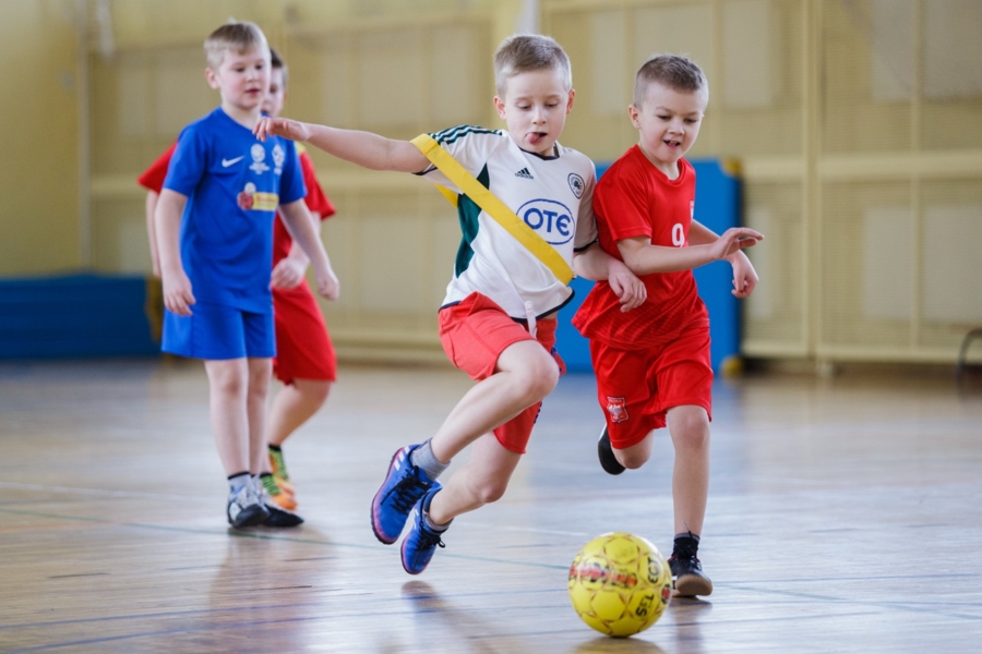 na zdjęciu dzieci grające w piłkę na hali